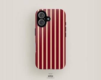 May include: A red and white striped phone case with a black camera lens cutout. The case is made of a hard plastic material and has a smooth finish.
