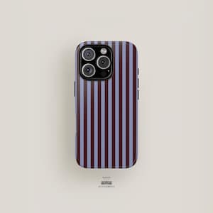 May include: A smartphone case with a vertical striped pattern in burgundy and light blue. The case has a glossy finish and a camera module with three lenses. The brand name "MAISON ACCESSOBELLE" is printed at the bottom.