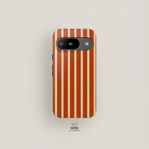 May include: A red and cream striped phone case with a camera lens cutout.