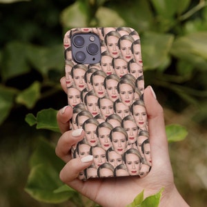 Puede incluir: Una funda de teléfono con un patrón repetido de la cara de una mujer. La funda es negra y la cara de la mujer es de piel clara con lápiz labial rojo.