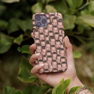 Puede incluir: Una funda de tel&eacute;fono con un patr&oacute;n repetido de la cara de un hombre. La funda es de color marr&oacute;n claro y la cara del hombre es de tono de piel claro.