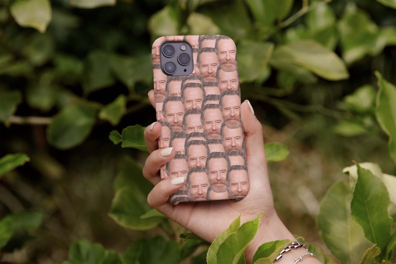 May include: A phone case with a repeating pattern of a man's face. The case is a light brown color and the man has a beard and gray hair.