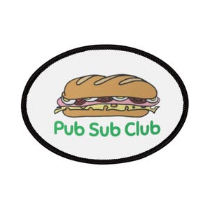 Puede incluir: Un parche ovalado blanco con borde negro que presenta un dibujo animado de un sándwich con el texto "Pub Sub Club" en verde.