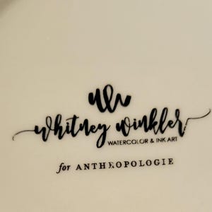 Pu&ograve; includere: Superficie color crema con testo nero. Il testo include il nome "Whitney Winkler" in corsivo, con "Watercolor & Ink Art" sotto. Le parole "for ANTHROPOLOGIE" sono in basso.