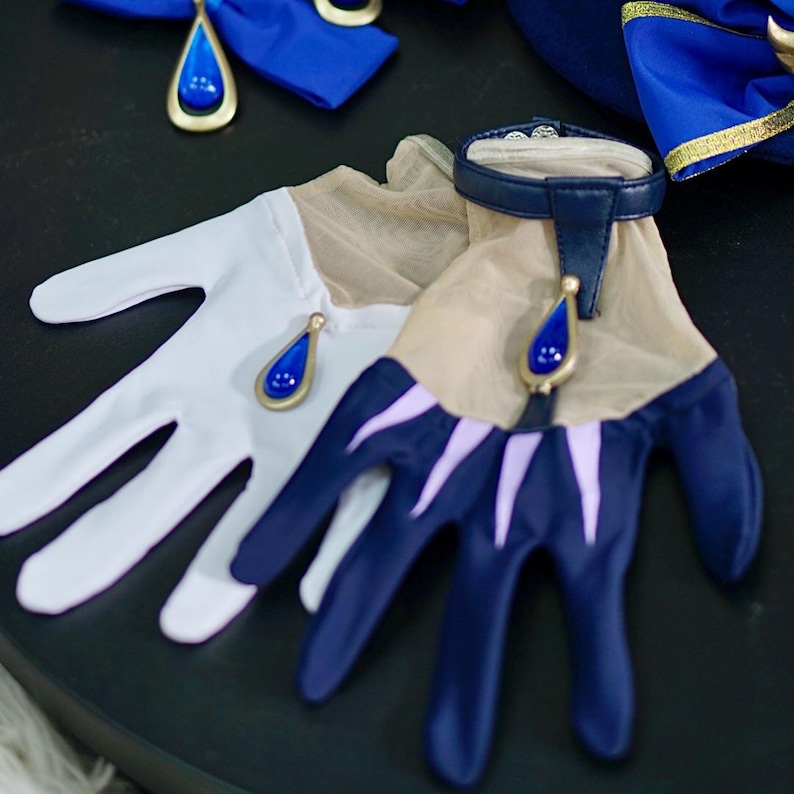 May include: A pair of gloves, one white and one blue with a mesh design. Both gloves have a gold accent with a blue teardrop-shaped gem.