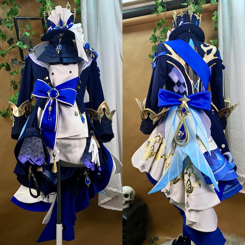 May include: A blue and white cosplay costume with a crown, a blue sash, and a blue bow. The costume is detailed with gold accents and a white skirt with a blue and white pattern.