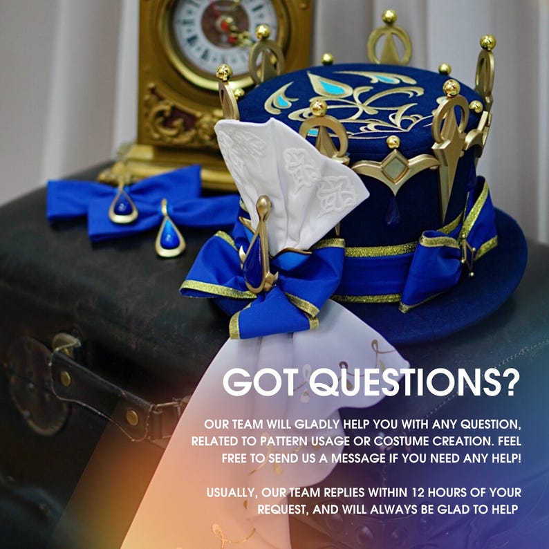 May include: A blue and gold crown-shaped hat with a white bow and blue ribbon. The hat is sitting on a brown suitcase with the text "GOT QUESTIONS?" on a white background.