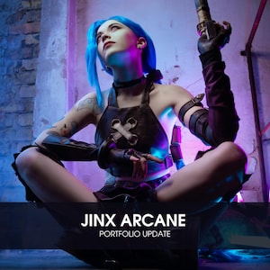 May include: A woman dressed as the character Jinx from the video game League of Legends. She is wearing a blue wig, a brown leather vest, and a black choker. She is holding a weapon in her right hand and is sitting on the ground. The background is a brick wall with neon lights.