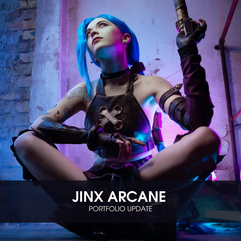 May include: A woman dressed as the character Jinx from the video game League of Legends. She is wearing a blue wig, a brown leather vest, and a black choker. She is holding a weapon in her right hand and is sitting on the ground. The background is a brick wall with neon lights.