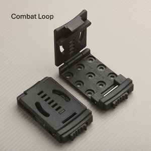 May include: Two black Combat Loop belt attachments. One is closed, showing a series of horizontal slots. The other is open, revealing a series of circular holes and a hinged design. The text "Combat Loop" is in the upper left corner.