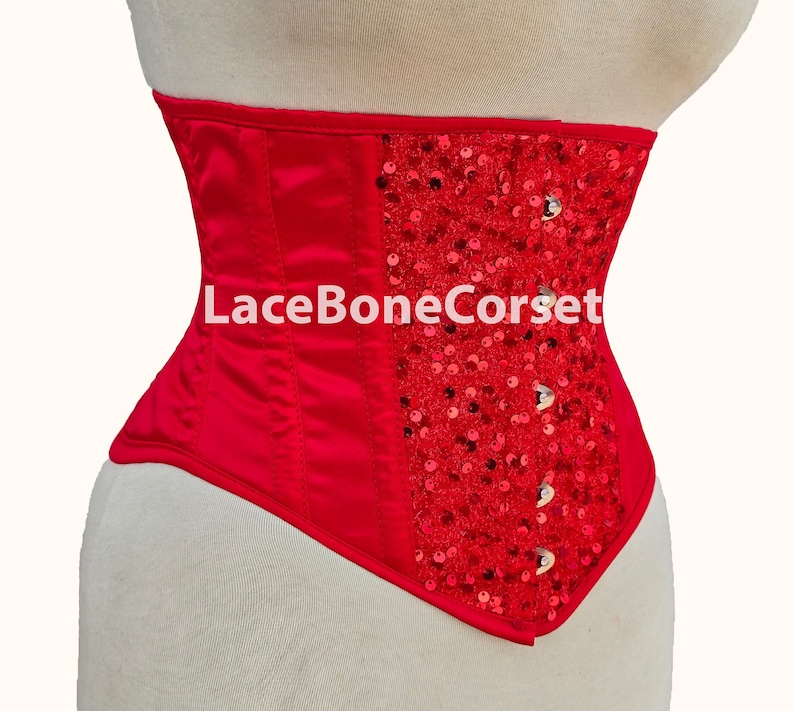 May include: Red satin corset with a panel of red sequins on the right side. The corset has a lace-up back and is made by LaceBoneCorset.