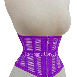May include: A vibrant purple corset with a mesh and vertical panel design, displayed on a mannequin. The corset features a front zipper and the text "Lacebone Corset".