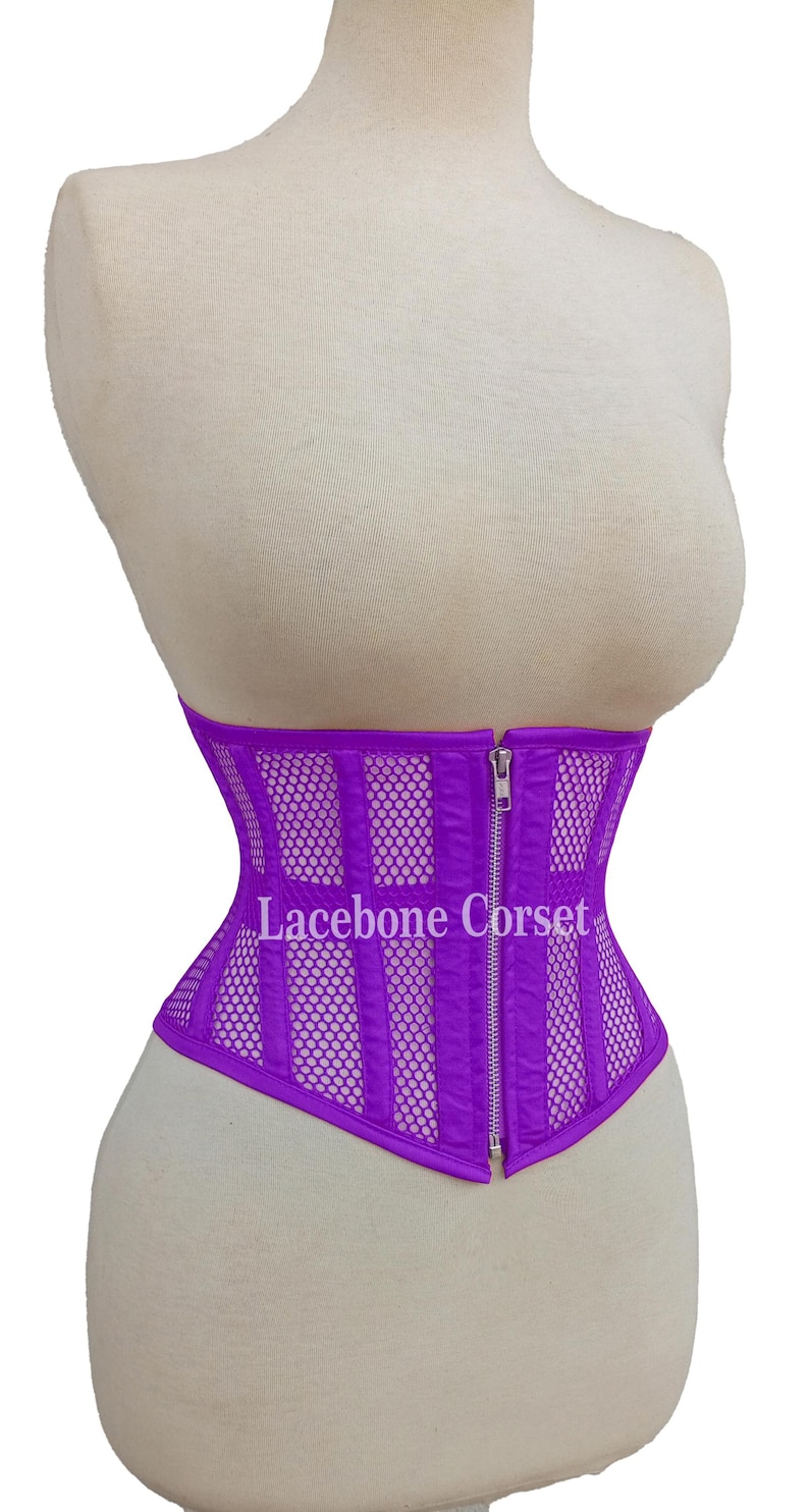May include: A vibrant purple corset with a mesh and vertical panel design, displayed on a mannequin. The corset features a front zipper and the text "Lacebone Corset".