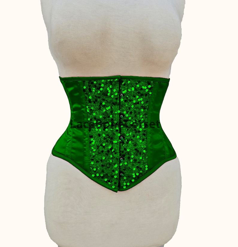 May include: A green satin corset with a pointed bottom and a row of green sequins down the front.