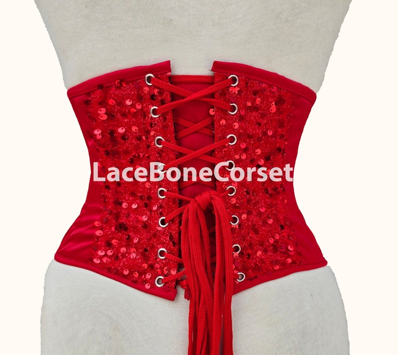 May include: Red corset with a lace-up back and sequins. The corset has a red lace-up closure and the text "LaceBoneCorset" is printed on the back.