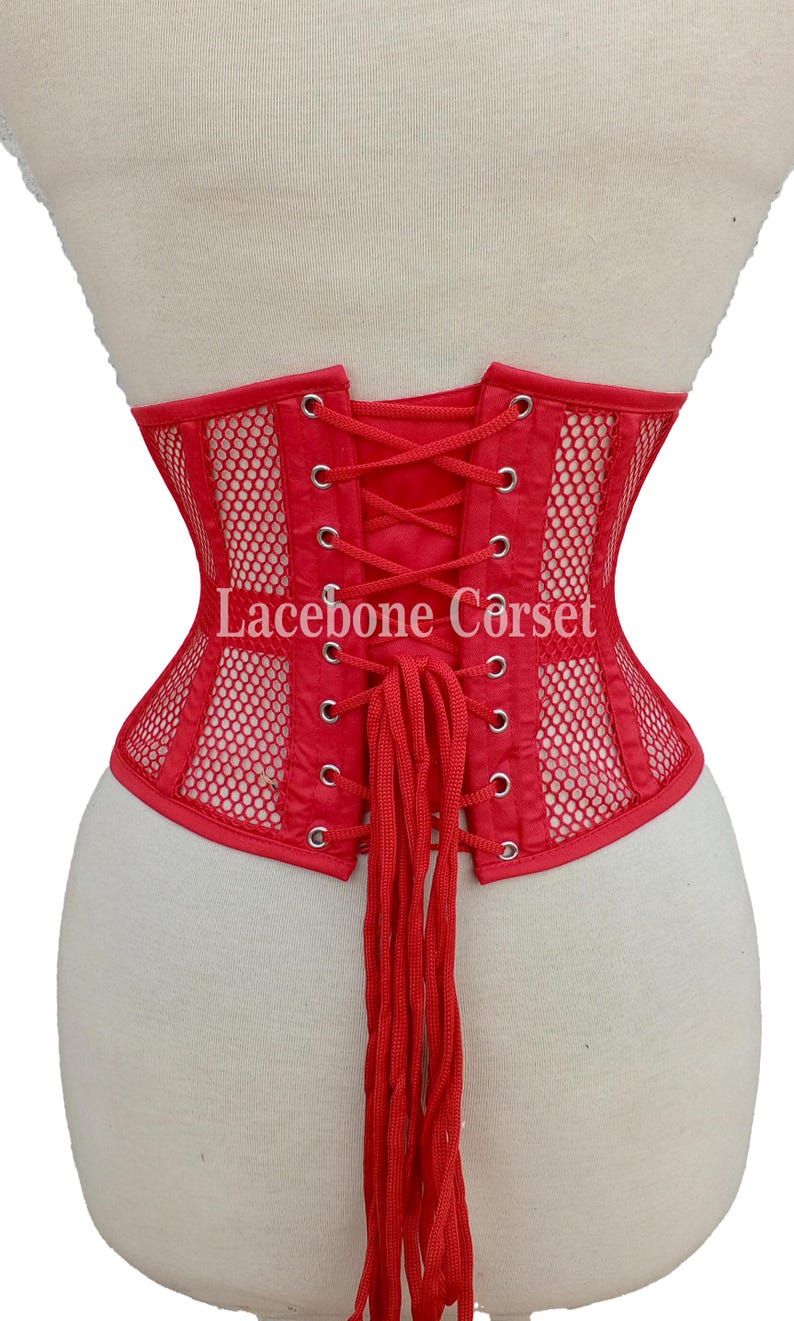 May include: Red corset with a mesh design and lace-up back. The corset has a structured shape and features the text "Lacebone Corset". The garment is displayed on a mannequin.