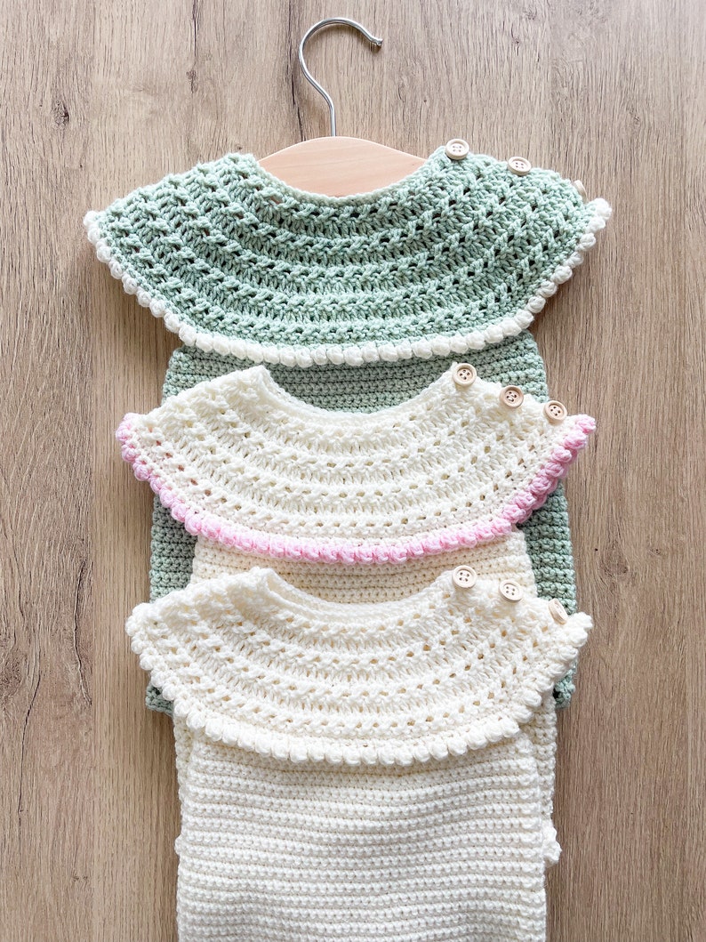 May include: Three crocheted collars in different colors, green, pink, and white, with wooden buttons. The collars are stacked on top of each other and hanging on a wooden hanger.