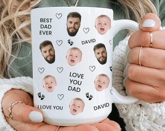Op de afbeelding: Witte keramische mok met meerdere afbeeldingen van een man en een baby, samen met de zinnen "BEST DAD EVER", "LOVE YOU DAD" en "I LOVE YOU". De mok bevat ook de naam "DAVID" en hart- en voetafdruk-afbeeldingen.