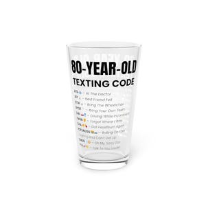 May include: A clear pint glass with the words "80-YEAR-OLD TEXTING CODE" printed in black. The glass features a list of texting acronyms and their meanings, such as "ATD - At The Doctor" and "BFF - Best Friend Fell".