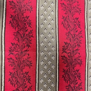 May include: A fabric with a repeating vertical stripe pattern. The design features alternating stripes of red and gray. The red stripes showcase a detailed floral motif in a darker shade of red. The gray stripes have a small floral pattern.