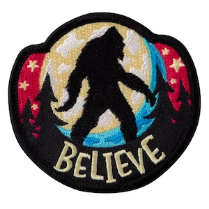 May include: A black embroidered patch with a silhouette of Bigfoot walking in front of a full moon. The moon is yellow with white clouds and a blue crescent moon. The background is black with red and blue trees and stars. The text "BELIEVE" is embroidered in yellow below Bigfoot.