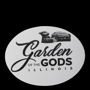 May include: A white circle sticker with black text that reads "Garden of the Gods Illinois". The sticker features a black and white illustration of rock formations.
