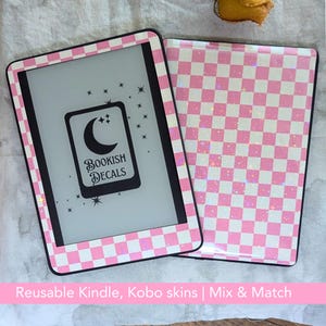 Puede incluir: Un juego de fundas y cubiertas para Kindle con un patrón de cuadros rosas y blancos. La pantalla del Kindle muestra un gráfico negro con una luna creciente, estrellas y el texto "Bookish Decals". El juego es reutilizable.