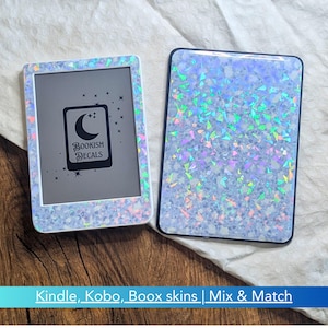 May include: Two e-readers featuring a light blue holographic skin with a scattered iridescent shard pattern. One device displays a screen graphic of a crescent moon and stars with the text Bookish Decals. The other device shows the back.