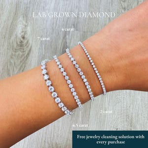 May include: Four silver-toned tennis bracelets featuring lab grown diamonds in varying sizes. The bracelets are labeled as 2 carat, 4 carat, 4.5 carat, and 7 carat. The text LAB GROWN DIAMOND and Free jewelry cleaning solution with every purchase appear.