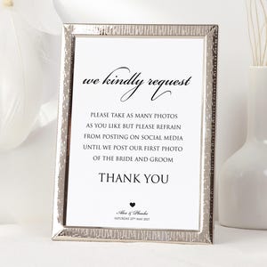 Puede incluir: Un letrero enmarcado con borde plateado y fondo blanco. El texto dice "we kindly request" seguido de instrucciones para fotos y redes sociales. El letrero incluye "Thank You" y los nombres "Alex & Phoebe" con una fecha.