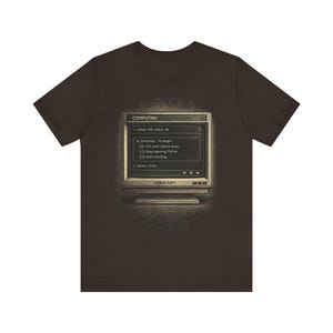Może przedstawiać: Ciemnobrązowy t-shirt z grafiką starego monitora komputerowego wyświetlającego tekst COMPUTAH, MAKE ME LOCK IN, Certainty: To begin: Put your phone away, Stop opening TikTok, Start working oraz Never mind, z napisem ERROR DEPT poniżej.