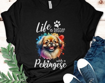 May include: Black t-shirt with a colorful watercolor illustration of a Pekingese dog. The text "Life is better with a Pekingese" is printed on the shirt.