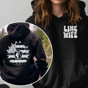 May include: Black hoodie with a white sunflower design on the back and the text "LINE WIFE" in a retro font on the front.