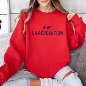 May include: Red sweatshirt with the text "VIVE LA R&Eacute;VOLUTION" in dark blue.