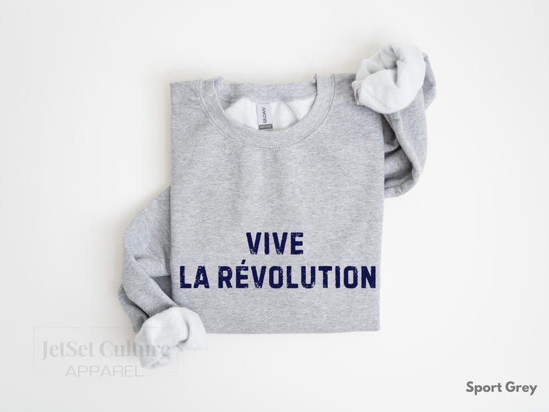 May include: A gray sweatshirt with the text "VIVE LA R&Eacute;VOLUTION" printed in blue.