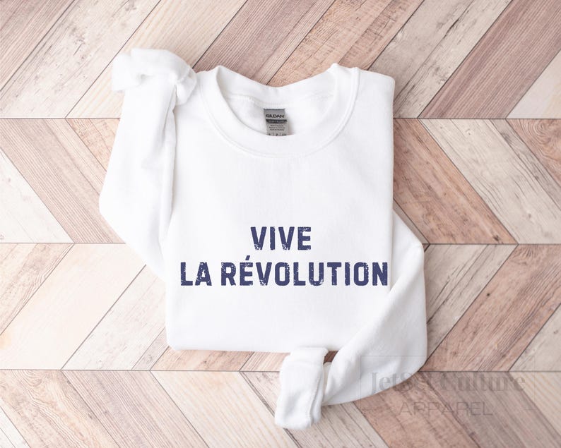 May include: White sweatshirt with the text "VIVE LA R&Eacute;VOLUTION" printed in blue.