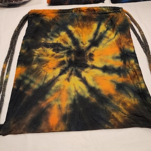 May include: A black drawstring bag with a tie-dye pattern in shades of orange, yellow, and green.
