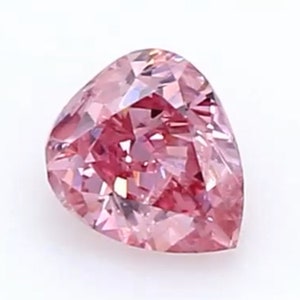 Könnte beinhalten: Ein birnenförmiger loser Edelstein mit einem leuchtend rosa Farbton und zahlreichen dreieckigen Facetten, die eine brillante, reflektierende Oberfläche erzeugen. Der Stein hat eine spitze Oberseite und eine abgerundete Basis mit Farbnuancen.