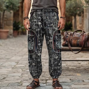 May include: A charcoal gray short-sleeved t-shirt paired with black cargo pants featuring an all-over white mushroom print. The pants include large side pockets with decorative spiral patterns and elasticized cuffs, worn with brown leather sandals.