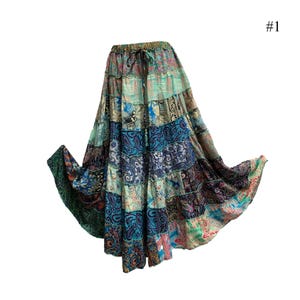 May include: A long, multi-colored patchwork skirt with a tiered design. The skirt is made of various fabrics in shades of blue, green, and brown. It has a drawstring waist and a flowing silhouette.