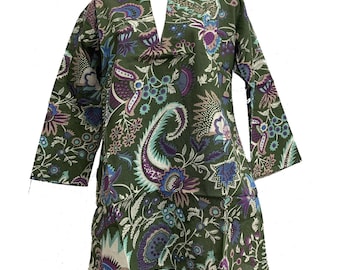 May include: Olive green tunic with a V-neck and long sleeves. The tunic features a vibrant floral pattern in shades of blue, purple, and white. The fabric has a soft, flowing appearance, suggesting a comfortable fit. The overall design is reminiscent of bohemian or resort wear.