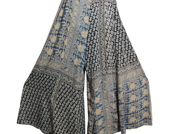 May include: Wide-leg pants with a patchwork design. The pants feature a combination of blue and black panels with floral and geometric patterns in cream and white. The fabric appears lightweight and flowing, suitable for warm weather.