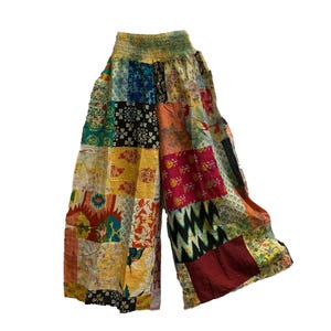Può includere: Pantaloni larghi a patchwork con un motivo floreale e geometrico colorato. I pantaloni hanno una cintura elastica e una vestibilità rilassata.