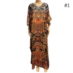 May include: A long, flowing caftan dress with a V-neck and short sleeves. The dress features an ornate, repeating pattern in black, gold, and red. The number "#1" is visible in the upper right corner.