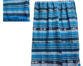 May include: Blue and grey striped cotton throw blanket with gold trim and blue tassels. The blanket is folded in half and has a fringed edge.