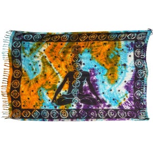 May include: A rectangular tapestry featuring a tie-dye background in shades of blue, orange, and purple with black star patterns. A central black silhouette of a person in a seated meditation pose displays vertical chakra symbols, framed by a border of circular chakra icons and fringed edges.