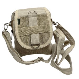 May include: A small, off-white hemp crossbody bag with a zipper closure and a flap with a buckle. The bag has a long adjustable strap and the word "HEMP" is printed on the front.