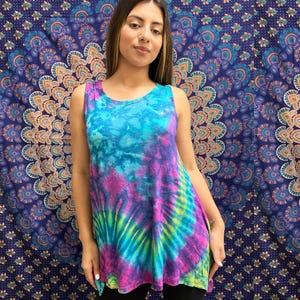 May include: A sleeveless tie-dye tank top in shades of blue, green, purple, and pink. The top has a loose, flowing fit and a round neckline.