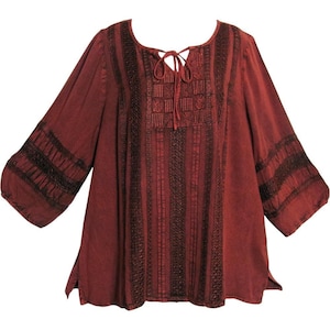 May include: A burgundy tunic top with three-quarter sleeves. The top has detailed embroidery on the bodice and sleeves, with vertical stripes and a tie-up neckline. The sleeves have a flared design.