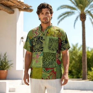May include: A short-sleeved shirt featuring a patchwork design in various shades of green, black, and red. The shirt has a mandarin collar, a partial button-down front placket with three buttons, and a single chest pocket on the left side.